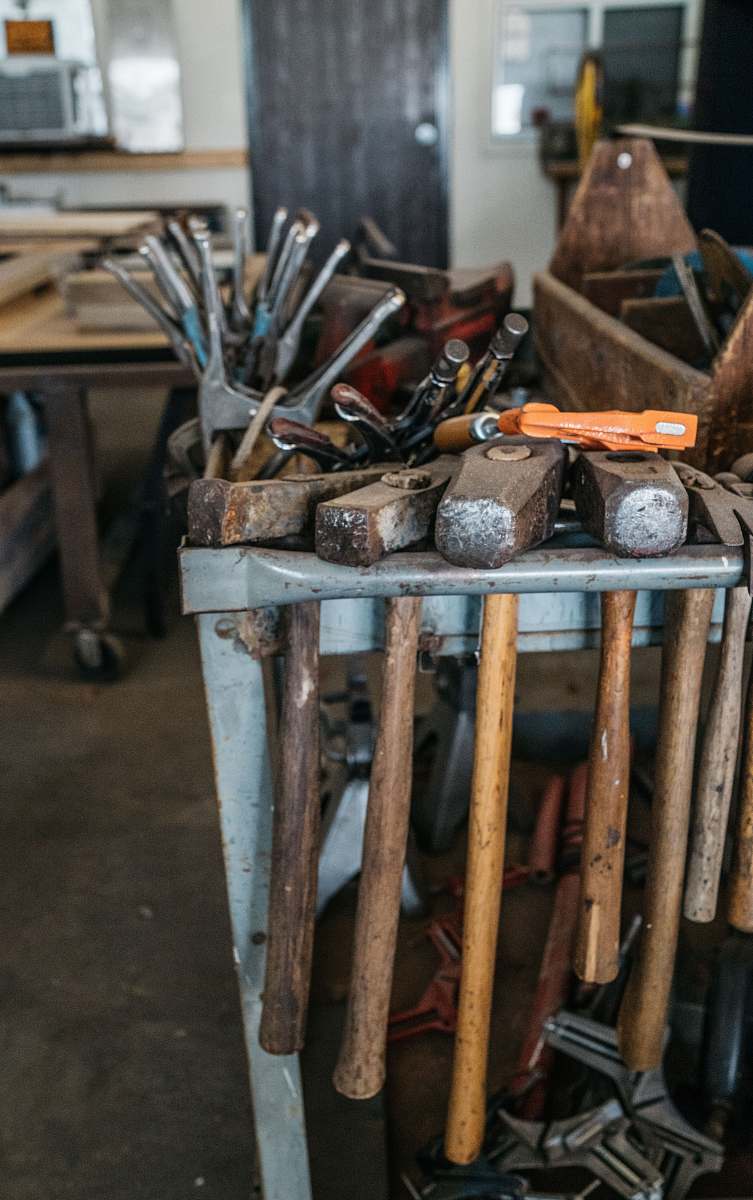phoenix several handheld tools on metal rack hammer